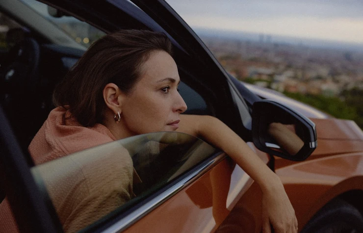 Chica sacando el brazo por la ventana del coche