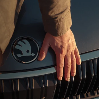 Mano tocando el capó de un skoda